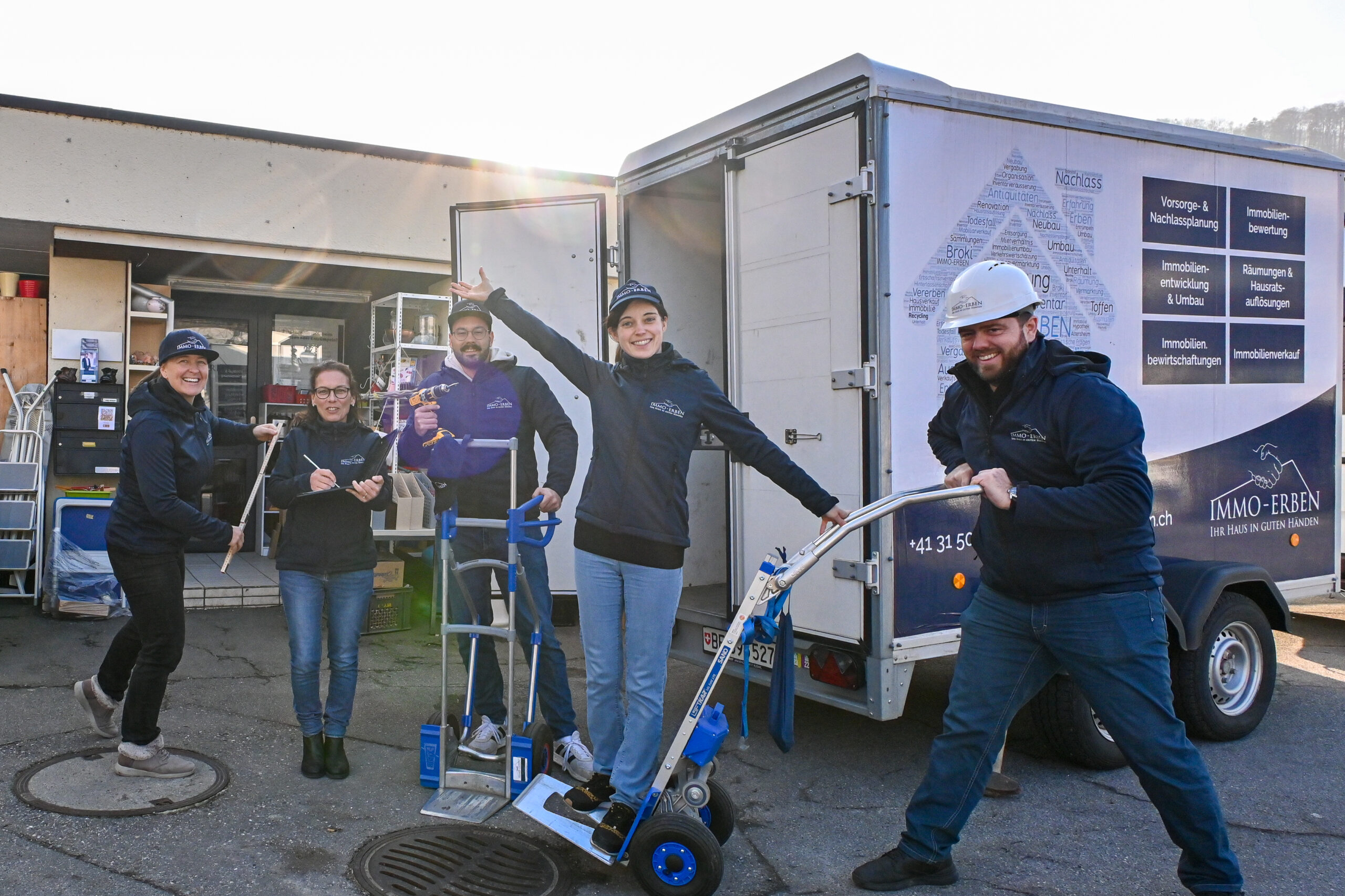 Das Räumungsteam der SCHATZKISTE in Arbeitskleidung mit Sackkarren und Anhänger